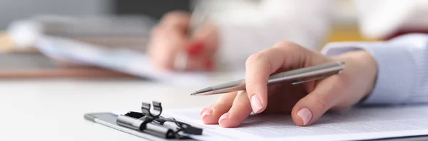 Main féminine avec stylo bille couché sur des documents gros plan — Photo
