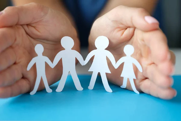 Women hands protect a family with children from paper