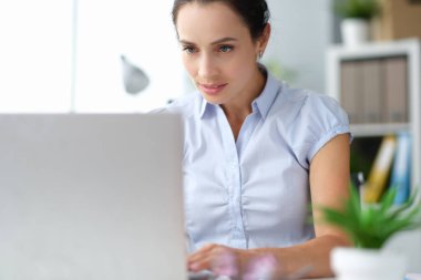 Bilgisayarda çalışan ciddi bir iş kadını.