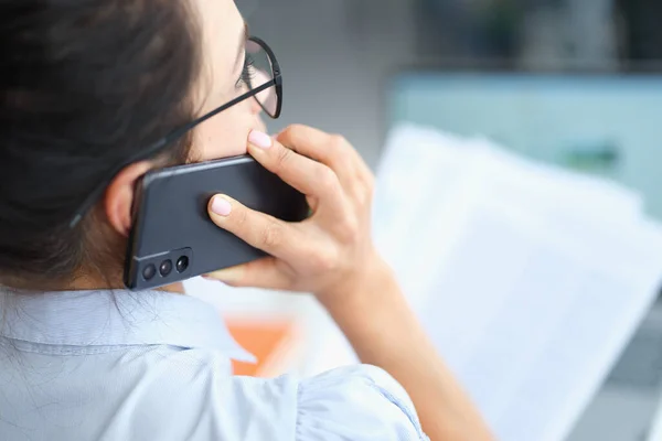 Empresária conversando no smartphone e lendo documentos resolvendo problemas de negócios corporativos — Fotografia de Stock