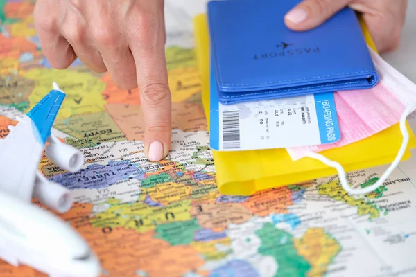 Punkty turystyczne palec na bilecie lotniczym do Grecji na mapie świata i posiada paszport — Zdjęcie stockowe