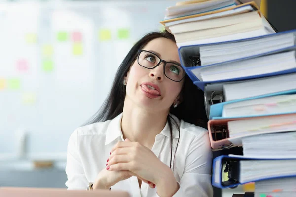 Tired young woman sitting at desk with lot of documents closeup — Stock Photo, Image