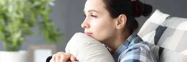 Портрет молодой грустной женщины, сидящей на диване — стоковое фото