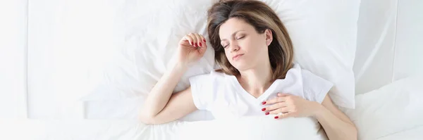Mujer joven está durmiendo en la cama blanca grande —  Fotos de Stock