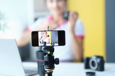 Müritlere lens incelemesi yaparken kameraya gülümseyen kadın