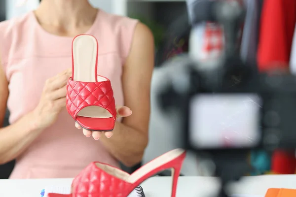 Блогер жінки показує нові червоні босоніжки з літньої колекції — стокове фото