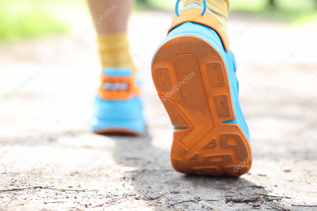 Leg of man taking step in sports sneakers closeup