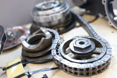 Servis masasında duran çelik zincirle bağlı dişli çarklar.