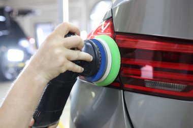 Arabanın arka farındaki çizikleri öğütücüyle kaldırıyorum.