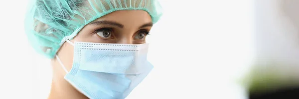Lékařka nosí ochrannou masku a čepici. — Stock fotografie