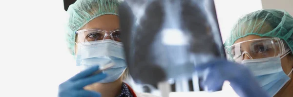 Лікарі стоять в офісі і дивляться на рентгенівські промені — стокове фото