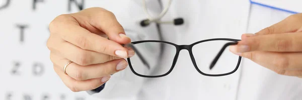 Doktor Womans händer håller nya glasögon i optik — Stockfoto