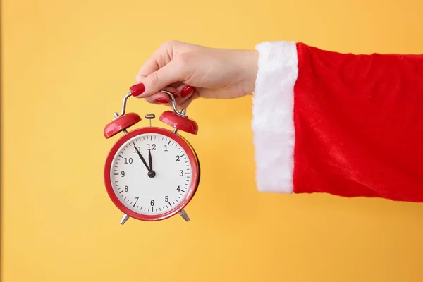 Reloj despertador rojo de la mano en Santa Claus traje de primer plano — Foto de Stock