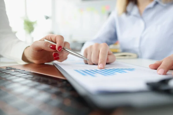 Female marketers discussing report in business graphs Stock Picture