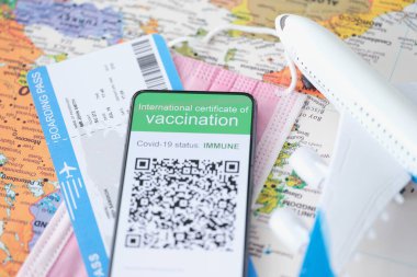 COVID-19 aşı pasaportu akıllı telefondan uçak biletinin yanında sergilenmektedir.