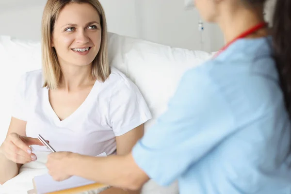 Doctor hands over signature document to patient at hospital closeup — Stock Photo, Image