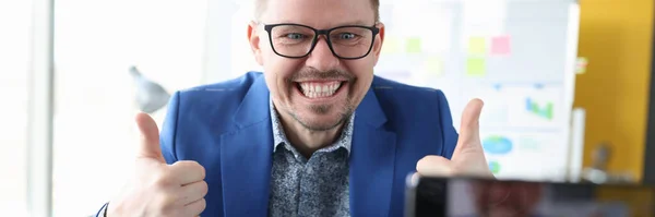 Man looking into camera of mobile phone and showing thumb up — Stock Photo, Image