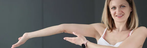 Young smiling woman showing her bent arm — Stock Photo, Image