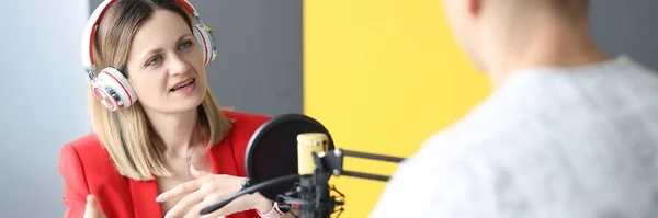 Kulaklıklı genç bir kadın radyoda röportaj yapıyor. — Stok fotoğraf