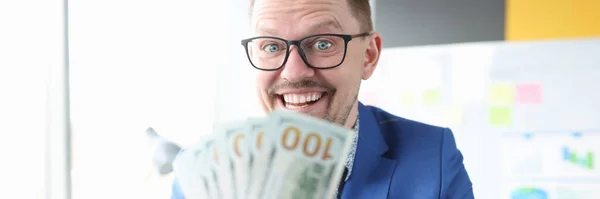 Joyful businessman holds cash in his hands — Stockfoto