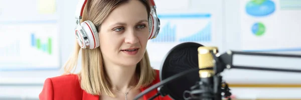 Woman with headphones in front of microphone at work table — Stock Photo, Image