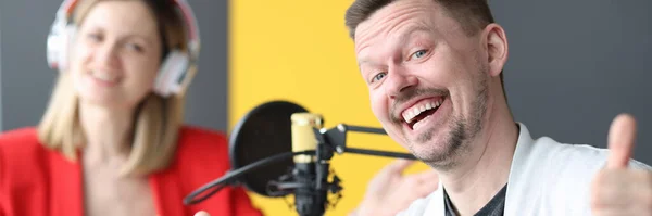 Joyful man and woman are working on air of radio station — Fotografia de Stock