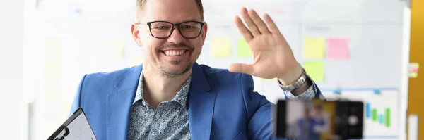 Businessman waving his hand to mobile phone camera — Stock Photo, Image