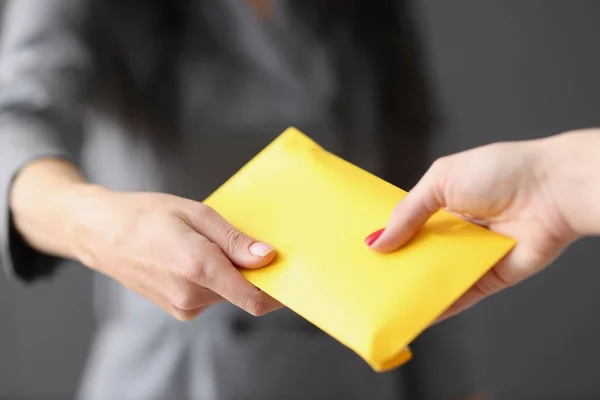Frau übergibt Mitarbeiter gelben Umschlag mit Geld — Stockfoto