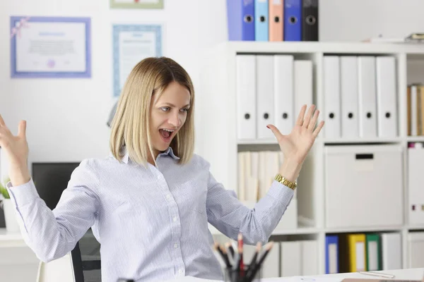 Joyful enthousiaste vrouw zit aan het bureau en kijkt in monitor. — Stockfoto