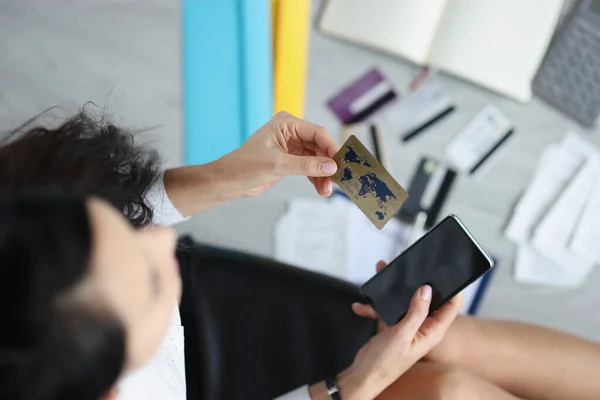 Kobieta trzyma w ręku plastikową kartę kredytową i smartfon — Zdjęcie stockowe