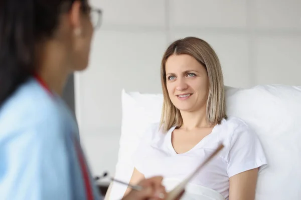 Läkaren kommunicerar med sängliggande patient på sjukhusavdelningen — Stockfoto