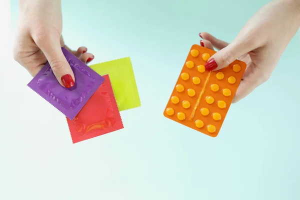 Pílulas contraceptivas e contraceptivos em mãos femininas — Fotografia de Stock