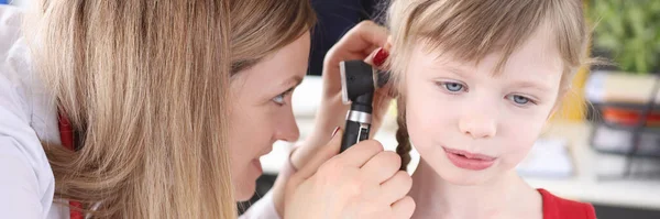 Docteur examine l'oreille avec un otoscope à la petite fille — Photo