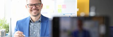 Sırıtkan işadamı elinde bir pano tutuyor ve online iş geliştirme kursları yürütüyor