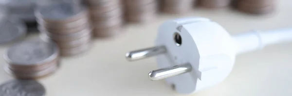 White electrical socket with coins lie on table — Stock Photo, Image