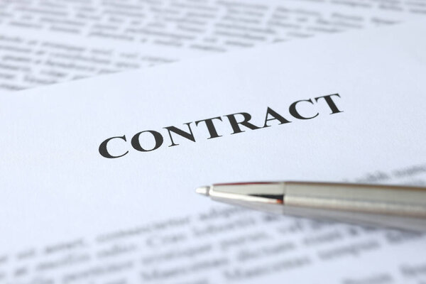 Metal ballpoint pen lying on documents with contract closeup