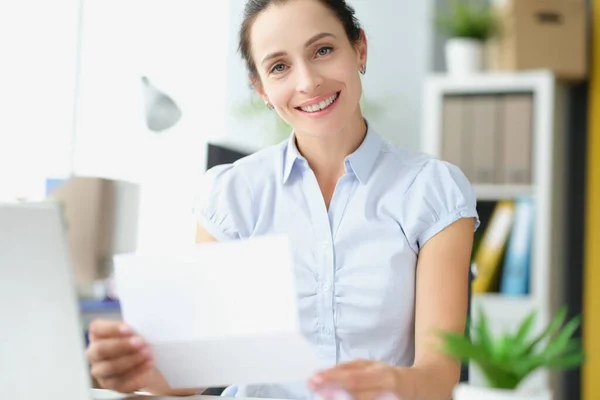 Красива усміхнена жінка тримає документ в руках крупним планом — стокове фото