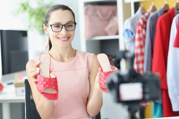 Блогер жінки демонструє шкіряні червоні сандалі на камеру — стокове фото