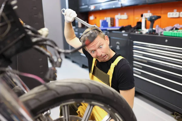 Pensive učeň zámečník myslí, jak opravit motocykl — Stock fotografie