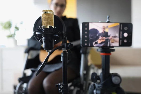 Γυναίκα καταγράφει βίντεο παίζοντας κιθάρα, ενώ κάθεται σε αναπηρική καρέκλα — Φωτογραφία Αρχείου