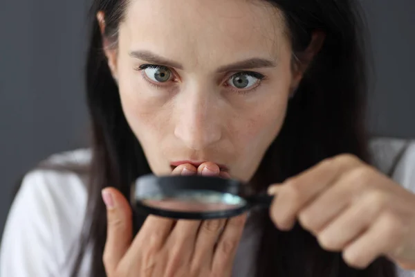 Image drôle de jeune fille surprise regardant la caméra à travers la loupe — Photo