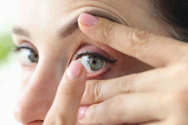 Ung kvinna sätter på kontaktlinser närbild — Stockfoto