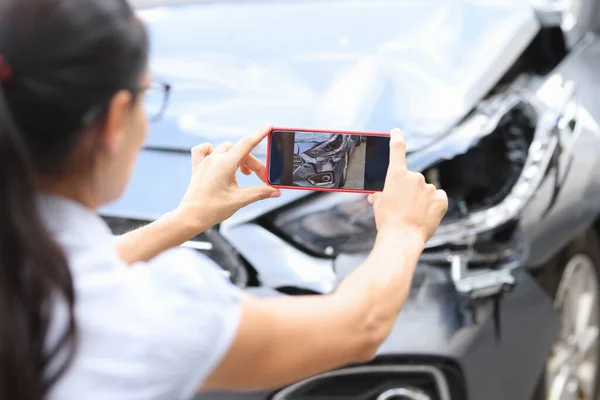 Agentin fotografiert Schaden am Auto nach Unfall mit Smartphone — Stockfoto