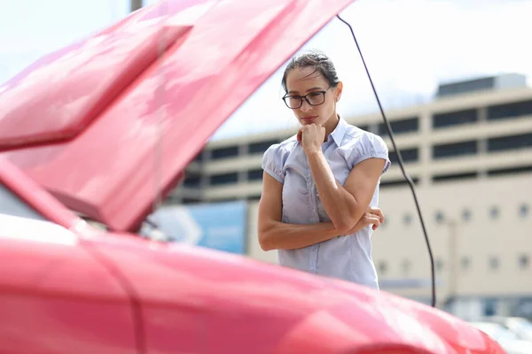 女性は車のエンジンを近くで見て — ストック写真