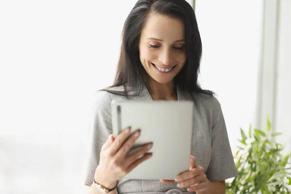 Sorrindo jovem mulher de terno segurando tablet digital — Fotografia de Stock