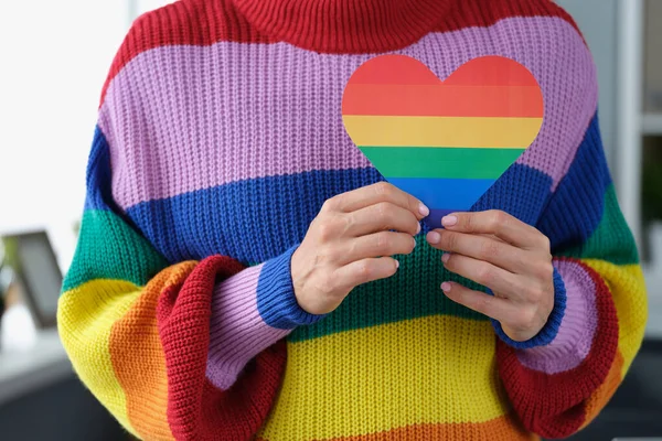 Donna in maglione arcobaleno che tiene il cuore di carta con simbolo lgbt primo piano — Foto Stock