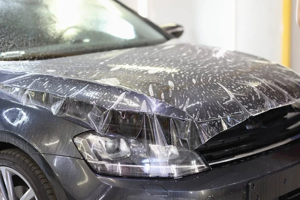 車のクローズアップのフードに貼られたポリウレタンビニールフィルム — ストック写真