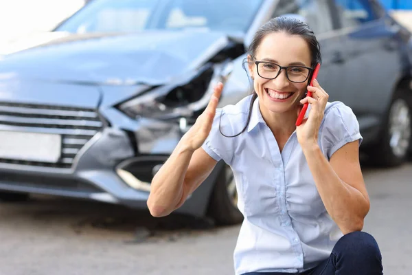 壊れた車の近くの携帯電話で話す満足した女性 — ストック写真