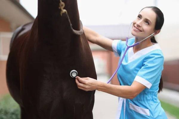 Mulher veterinária escuta de perto estetoscópio cavalo — Fotografia de Stock