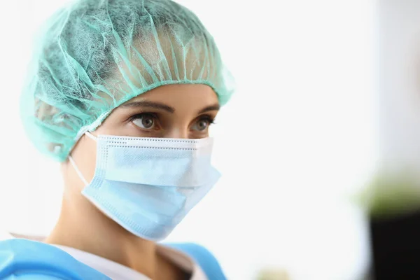 The female doctor wears a protective mask and cap — Stock Photo, Image